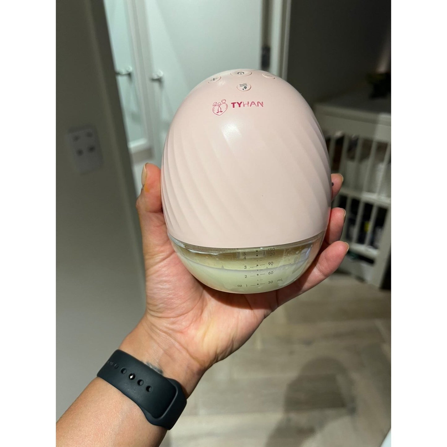 A mum showing the Tyhan wearable breast pump and the amount of milk she collected while cooking dinner and cleaning up