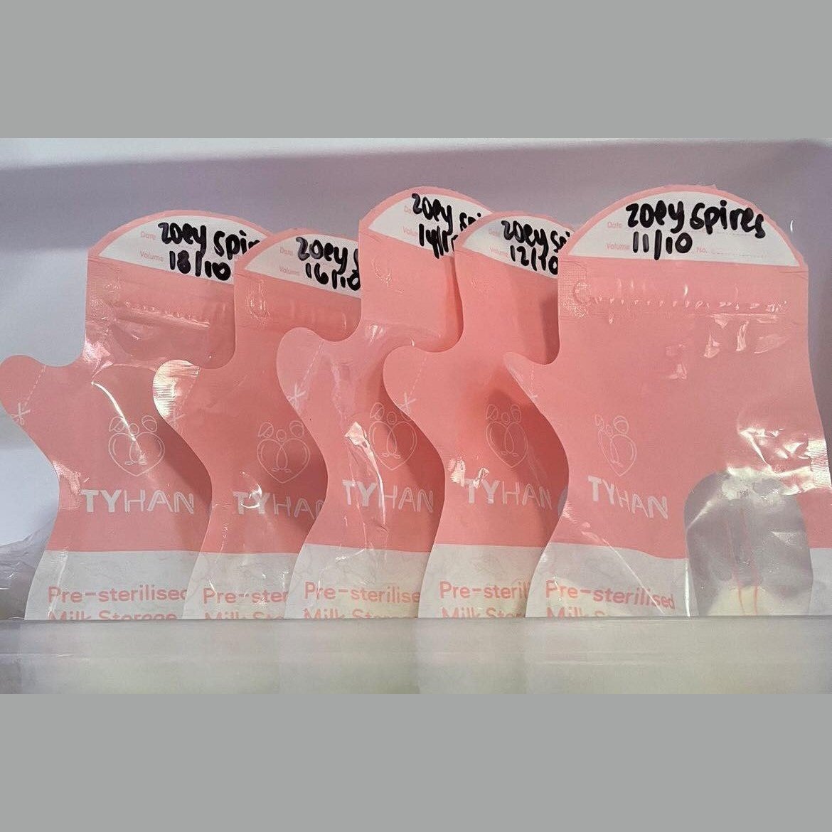Dated breastmilk storage bags filled with milk in the fridge for storage