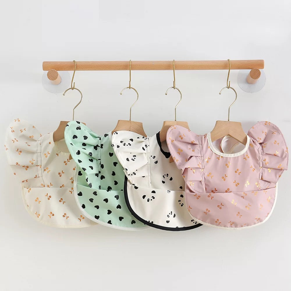 A photo of four different designs of fashionable and eco friendly baby bibs