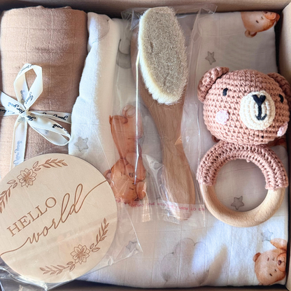 Image of baby shower gift box with two blankets and muslin wraps with brush, rattle and newborn plaque