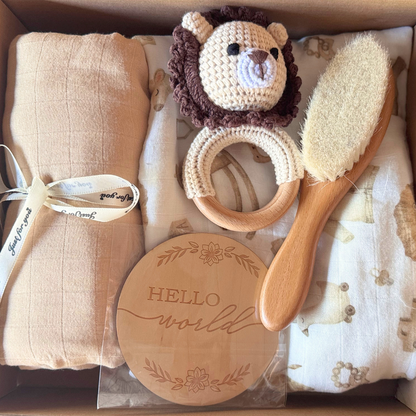 Image of baby shower gift box with two blankets and muslin wraps with brush, rattle and newborn plaque