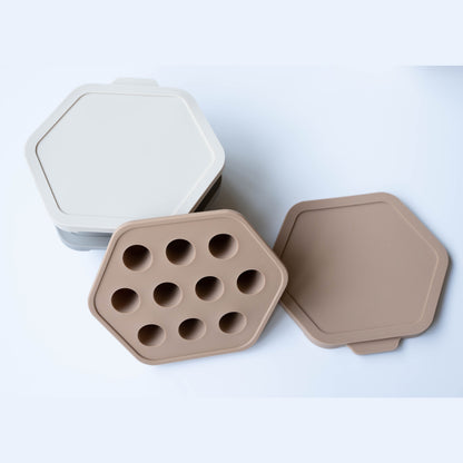 Hexagonal baking tray with multiple holes on a light gray background