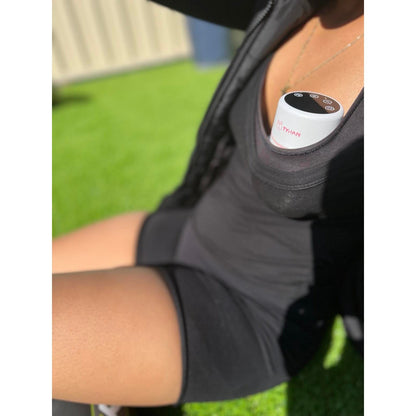 Mum using a portable breast pump while sitting outside enjoying the sun 